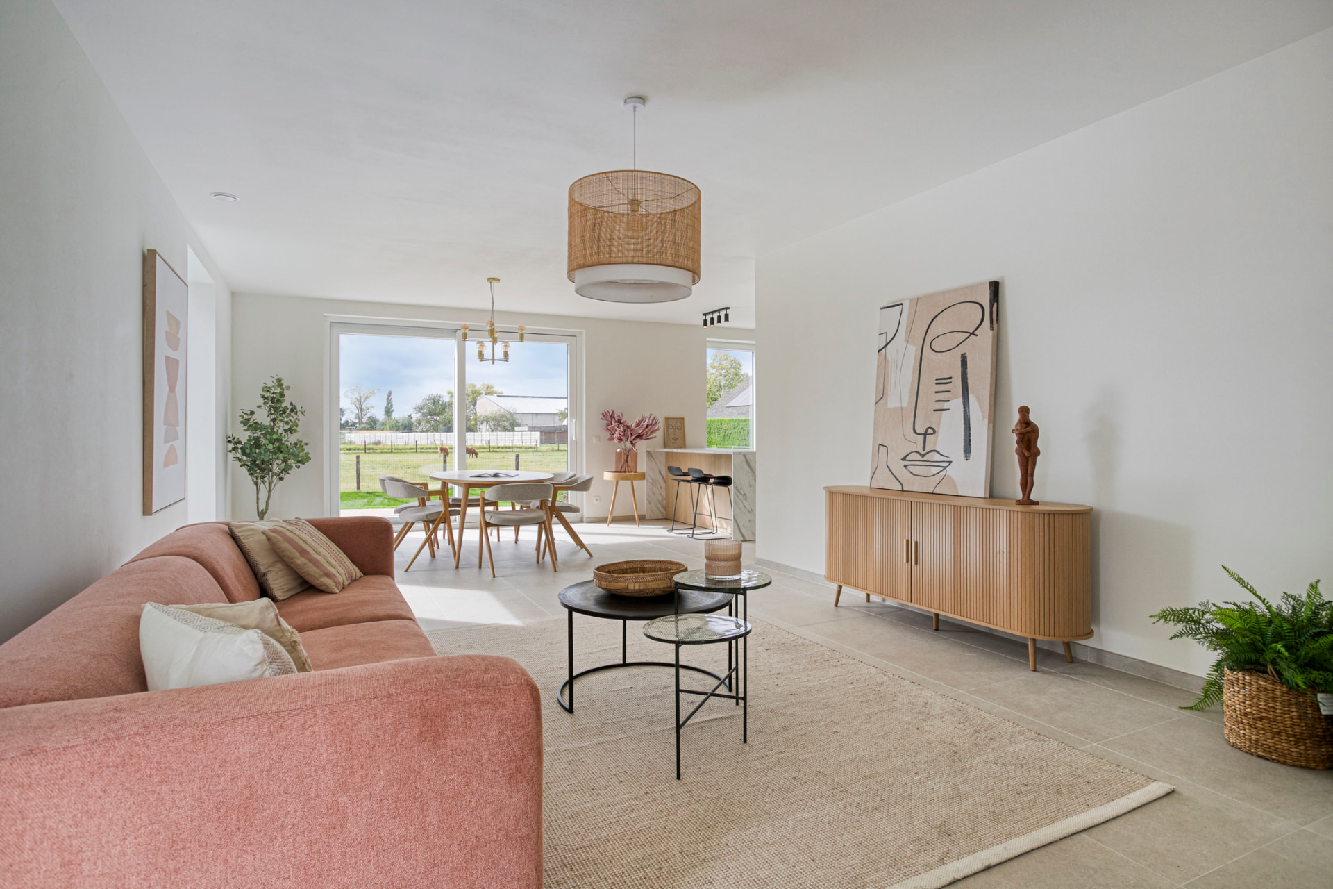 Living met rode bank, houten vloer en hoge ramen in de modelwoning