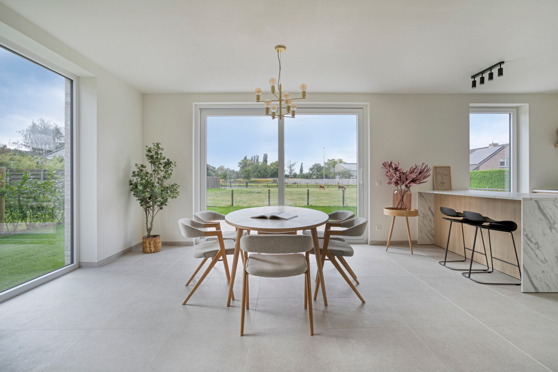 Lichte eetkamer met grote ramen in de modelwoning
