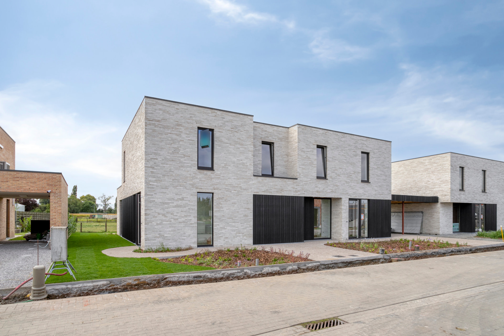 Nieuwe gevels in lichtbaksteen met zwart lattenprofiel aan de Bareelweg